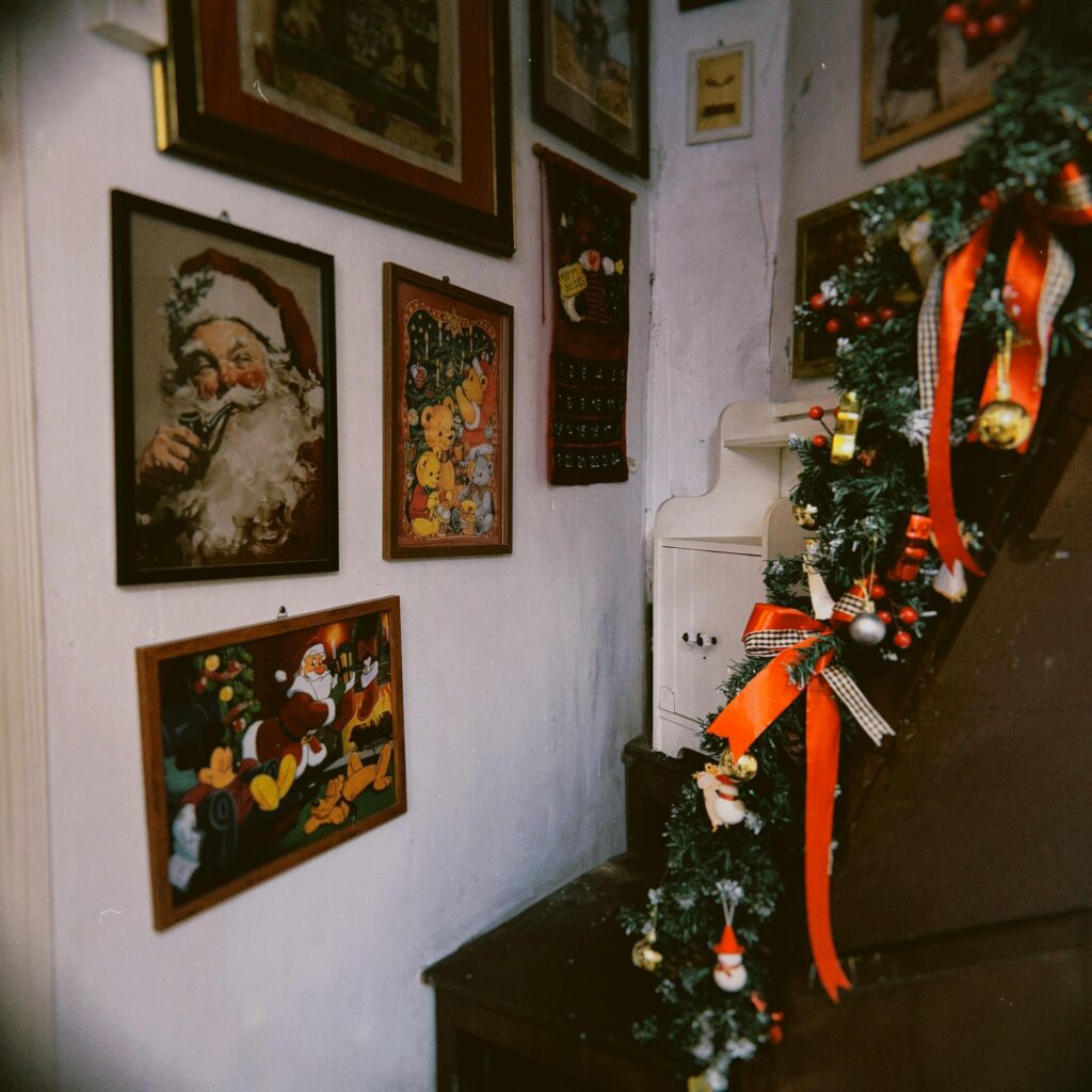 Festive indoor Christmas setting with vintage Santa Claus paintings and garland.
